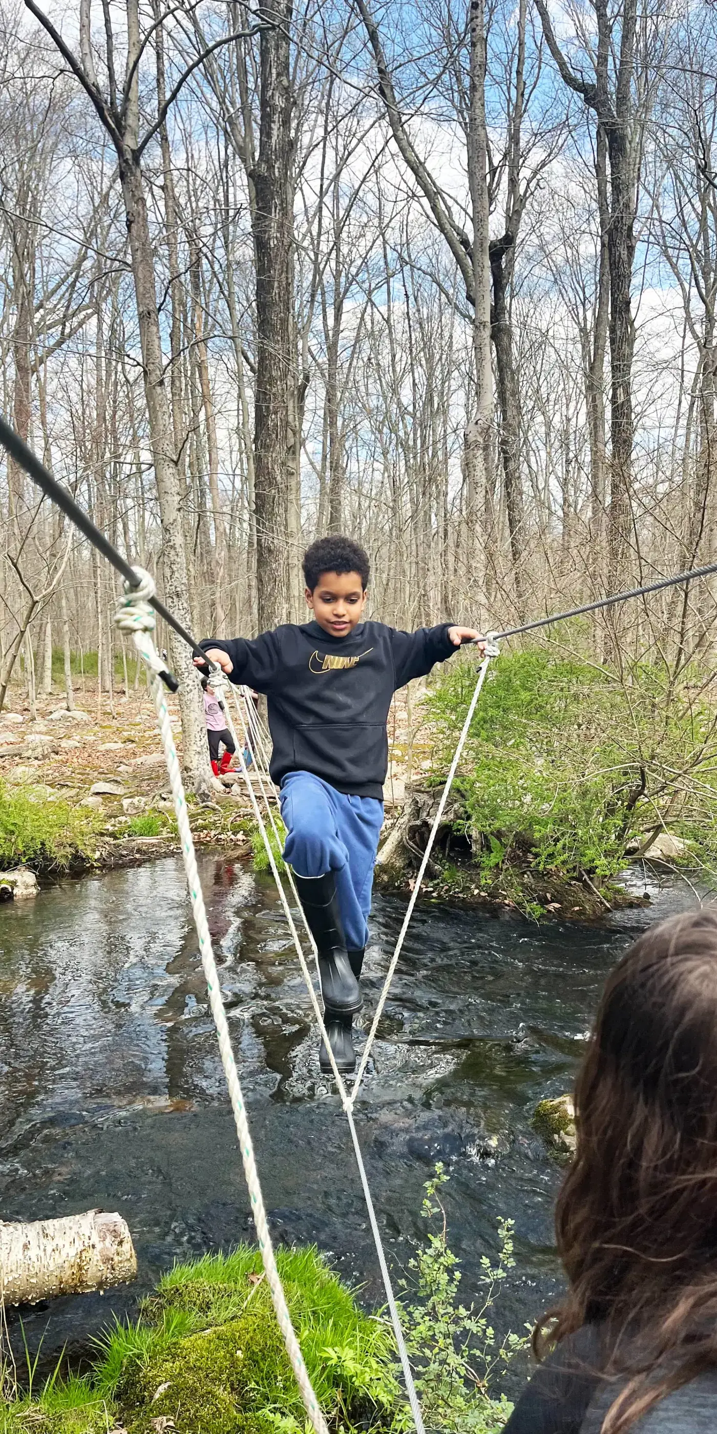 student-walking-across-river